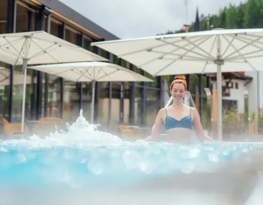 Whirlpool Frau schwimmt in einem Außenpool.