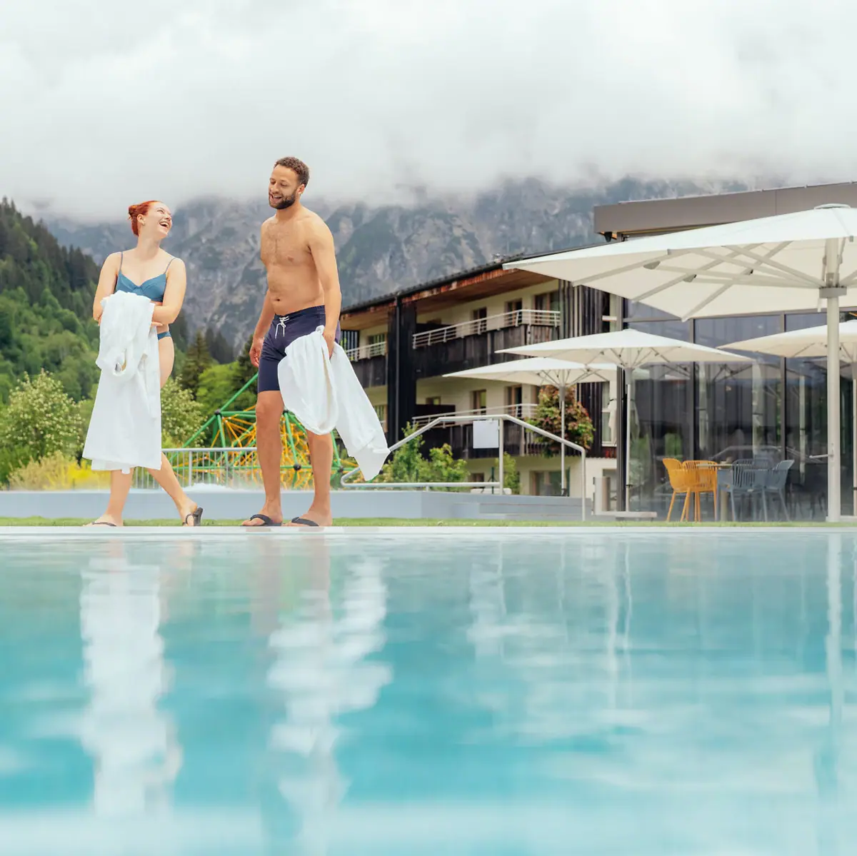 Paar am Pool Ein Mann und eine Frau stehen neben einem Pool.