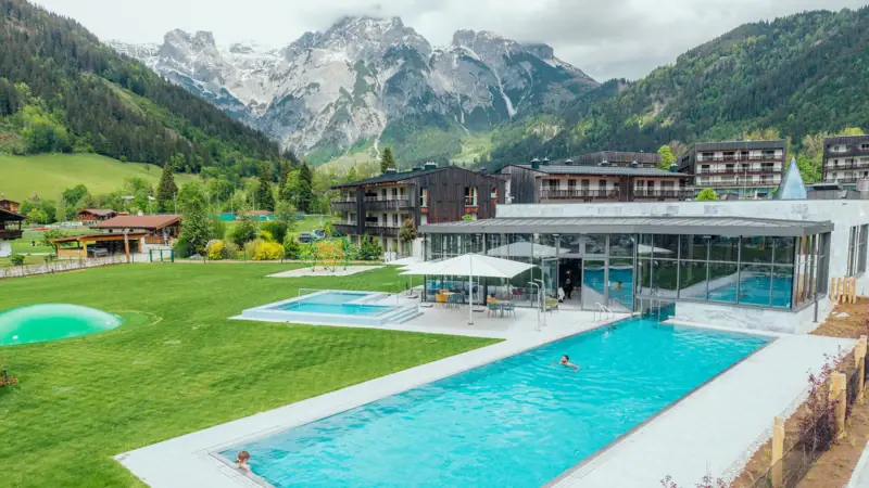 Badehaus Außenpool Schwimmbecken mit einem Gebäude und Bergen im Hintergrund