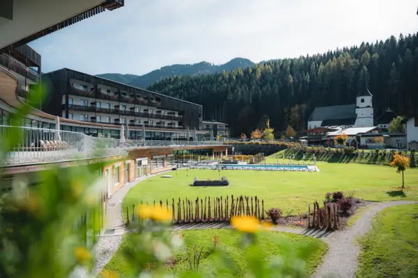 Bergresort Werfenweng Grüne Wiese mit einem Gebäude im Hintergrund