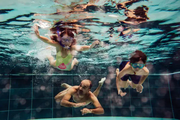 Familienspaß Eine Gruppe von Menschen schwimmt unter Wasser im Badehaus Werfenweng.